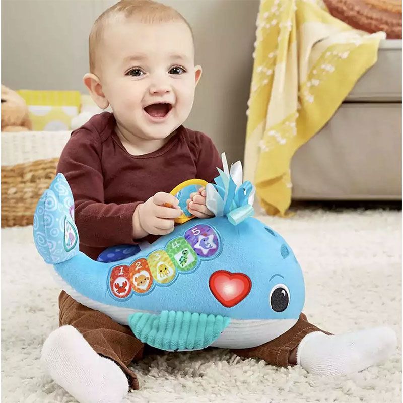 Бебешка мека интерактивна играчка VTech Snuggly Ocean Whale – Плюшен кит с пиано клавиши, 9 песни, 15 мелодии и фрази на английски език (3–24 месеца)